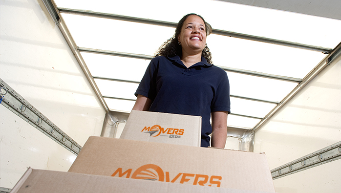 Woman providing top class moving services NYC has, and carrying boxes