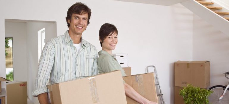 Couple carrying moving boxes