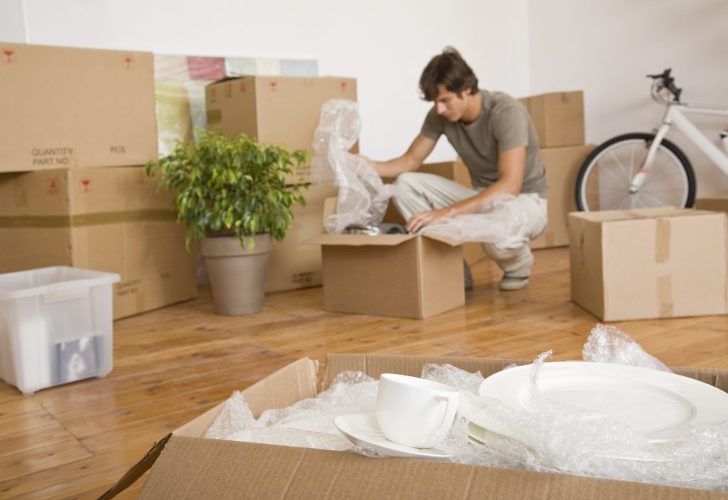 Man unpacking moving boxes after Brooklyn local movers have left