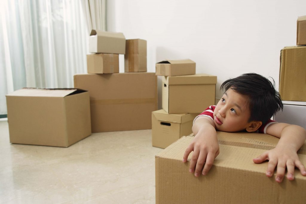 Boy surrounded by moving boxes.