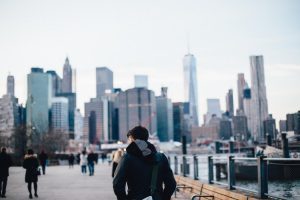 Man looking at highrises from Brooklyn.