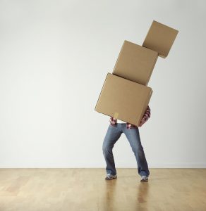 A man carrying a stack of moving boxes.