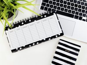 black and white timetable notebook on white laptop