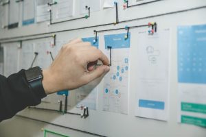 person working on blue and wait paper on a board